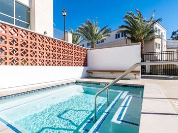 A pool with a diving board and a wall with a lattice pattern.
